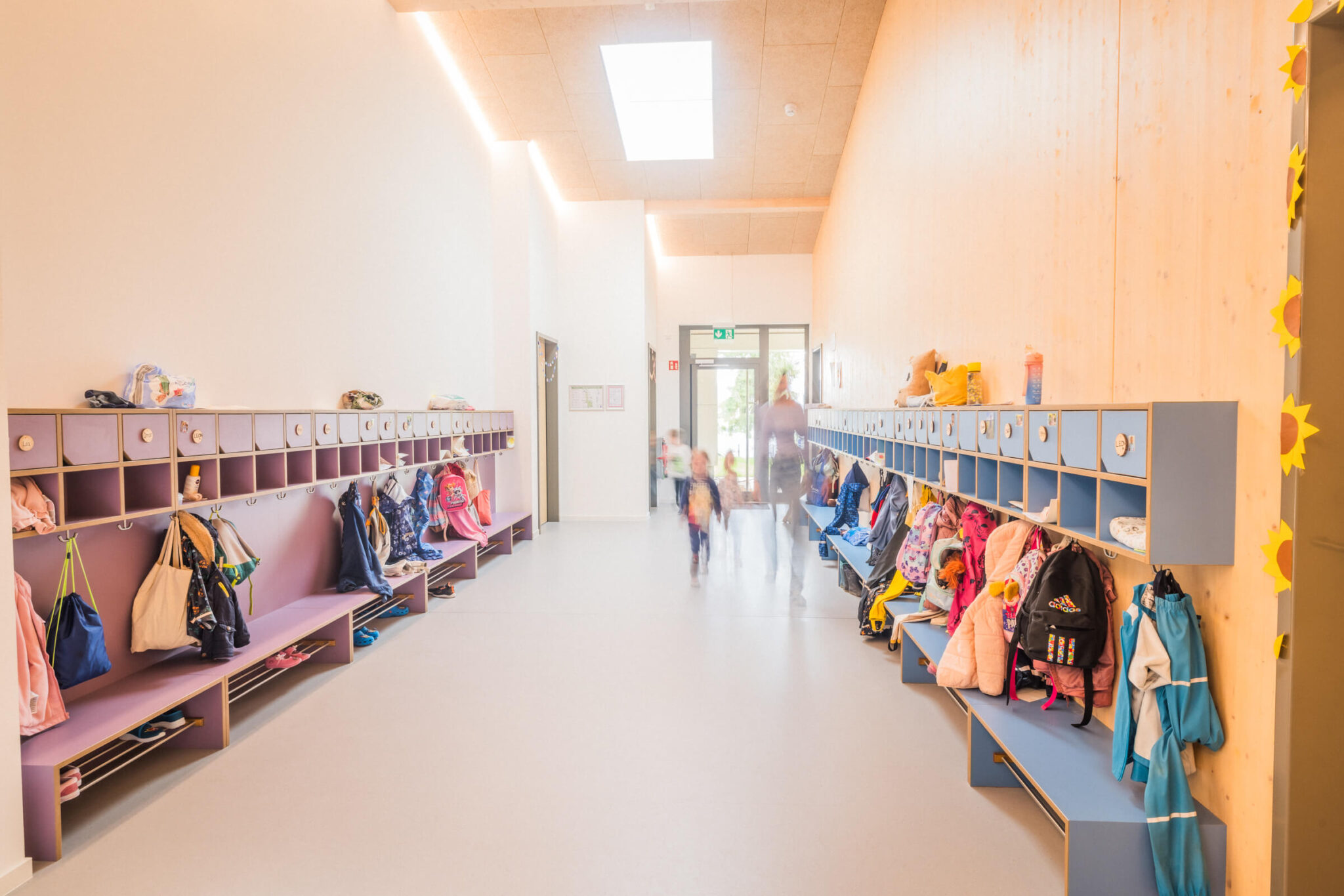Garderoben vor Gruppenräume in der BRK KiTa in Naila mit rennenden Kindern